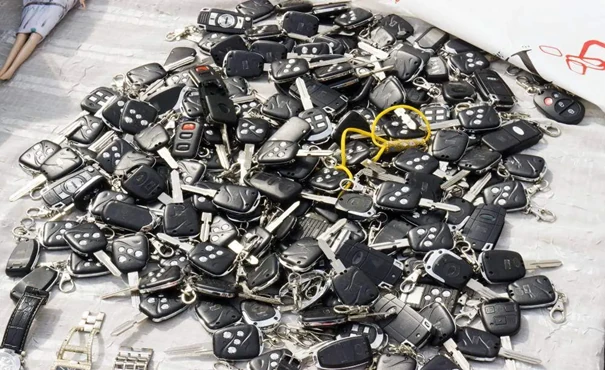 A bunch of car keys on staked on a table