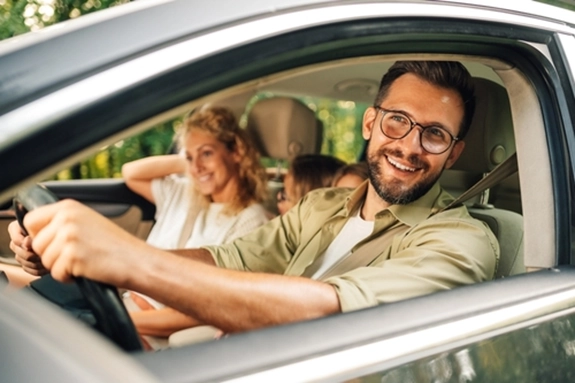 happy and sage family sitting in a car