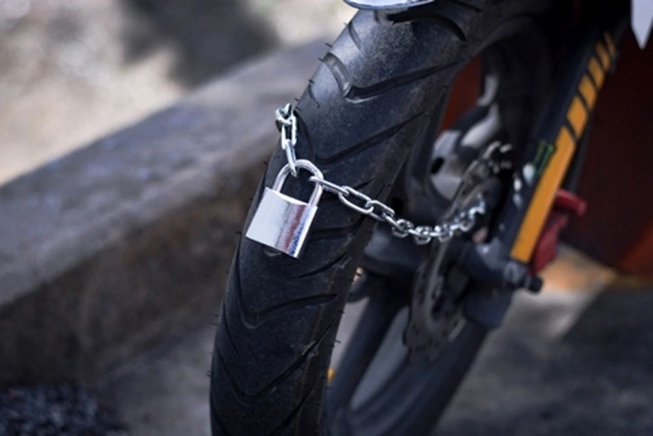Motorbike wheel locked with a padlock and chain