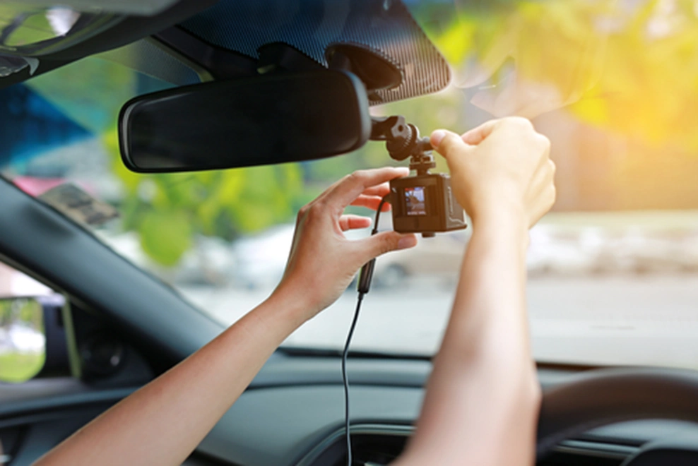 a person mounting a dashcam in a car