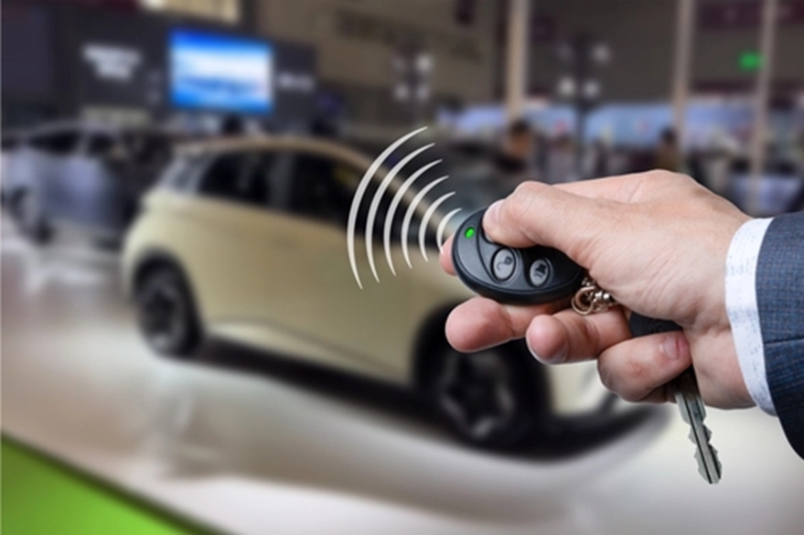 hand holding a car key pressing a button
