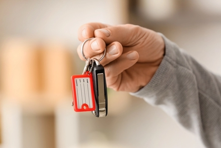 A hand holding a flip car key