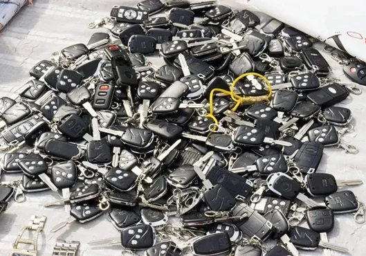 A bunch of car keys on staked on a table