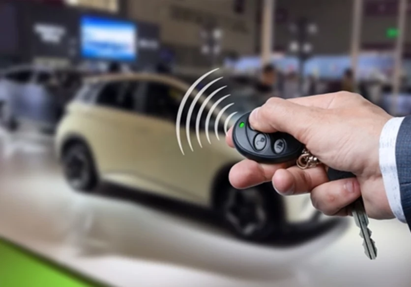 hand holding a car key pressing a button