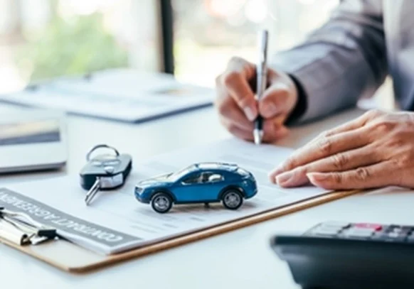 a man writing a car insurance document